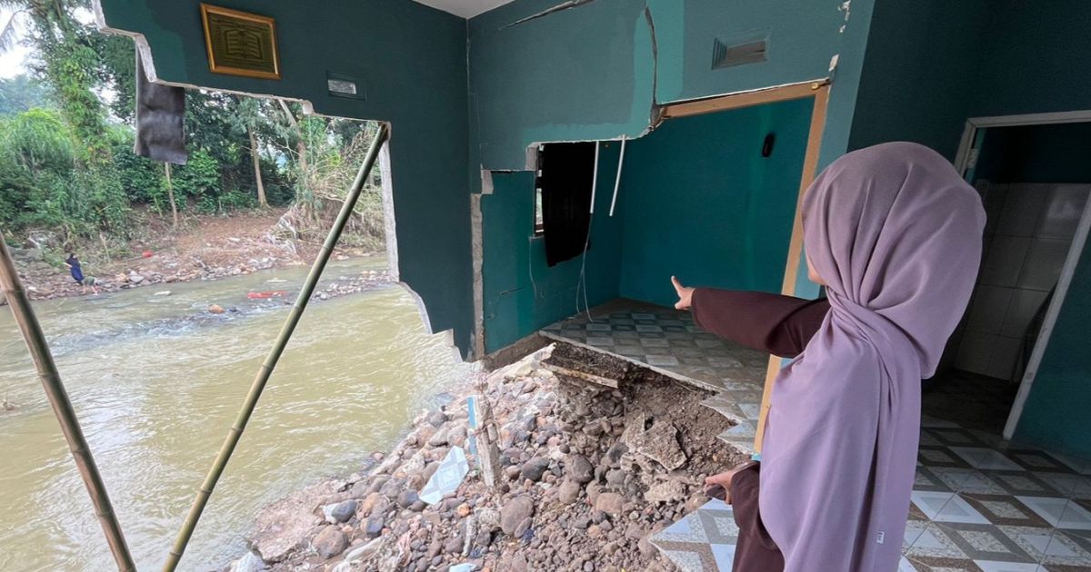 Mutmainah menunjukan rumahnya yang hancur akibat luapan sungai Citempuhan. Foto : bogorplus